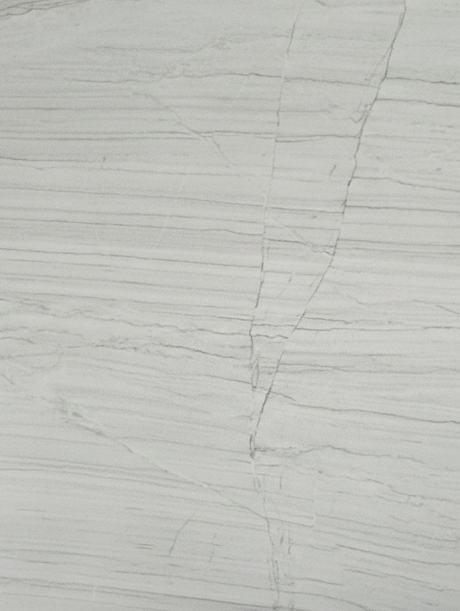 Calacatta Lux, close-up of a pale grey-white slab with fine horizontal grey lines and one thin vein curving down