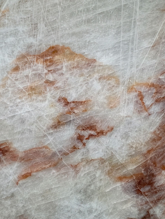 Crystallo Rose, close-up of a milky white slab with copper-orange patches and fine crystalline lines
