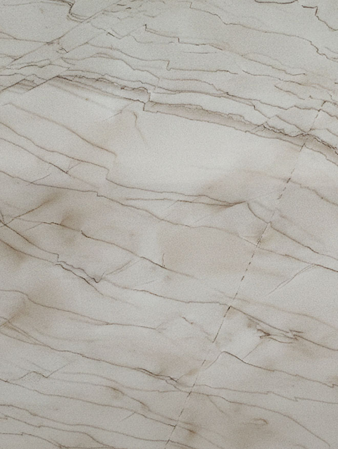 Monaco, close-up of a cream-white slab with thin brown veins running diagonally across soft beige clouds