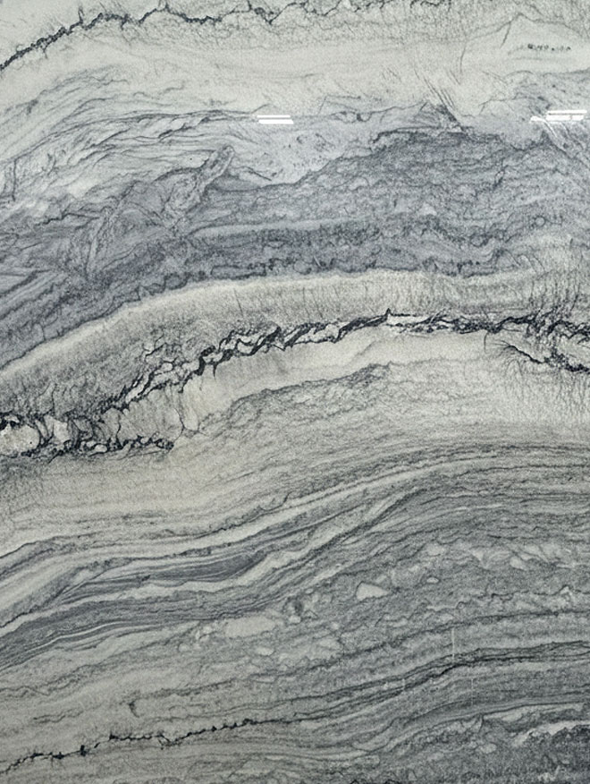 Stratus Blue, close-up of a slab in layered blue-grey and white bands with a dark jagged vein across the middle