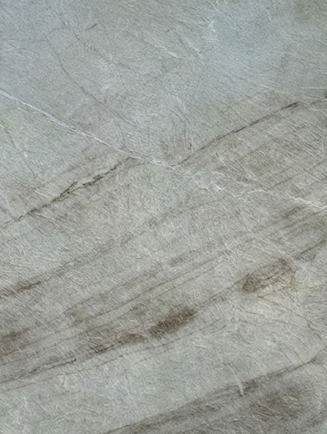 Taj Mahal, close-up of a soft grey-green slab with fine pale veins and brown-grey streaks sloping diagonally